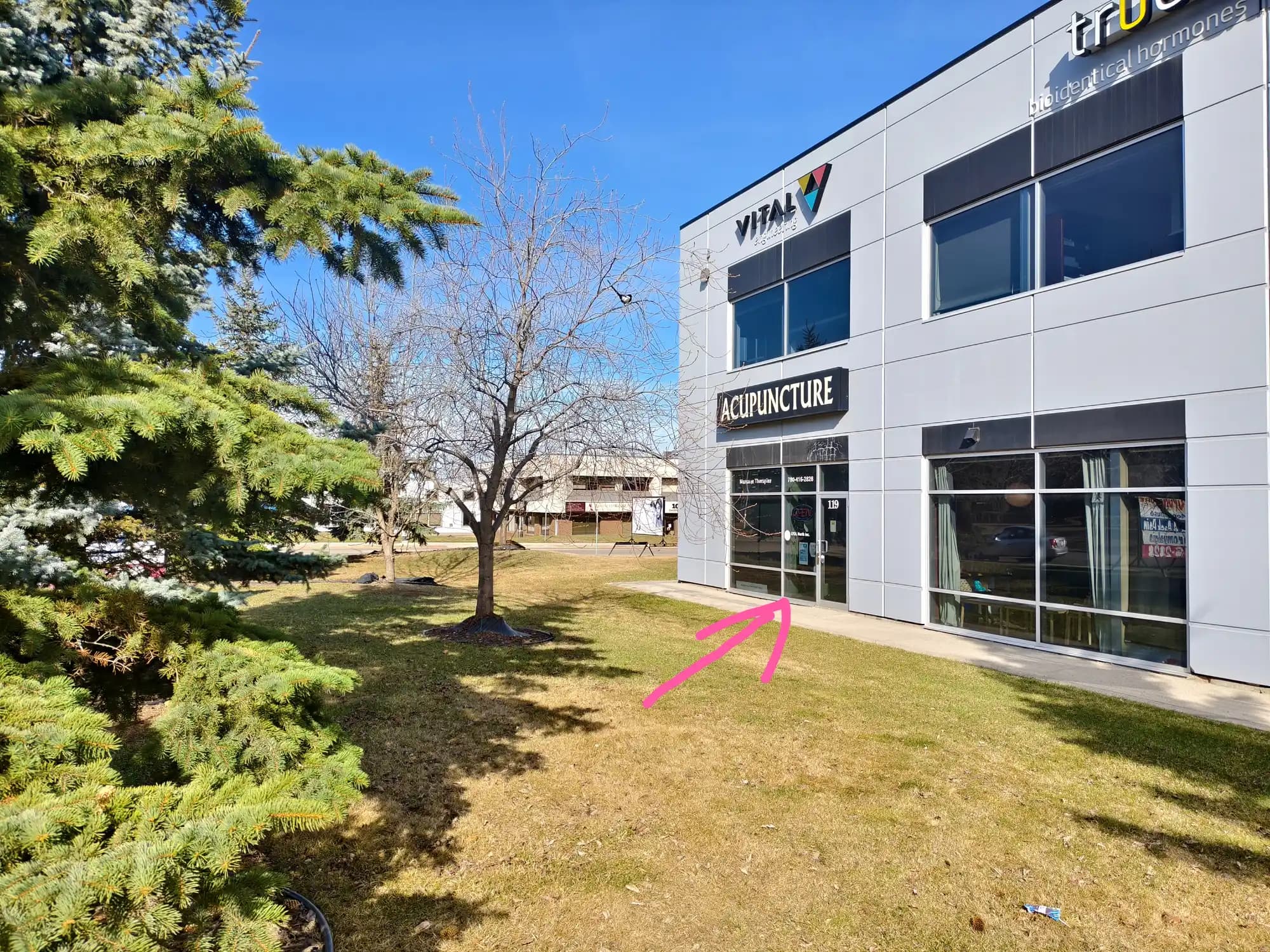The building with the ACUPUNCTURE sign; a pink arrow points to the studio entrance.